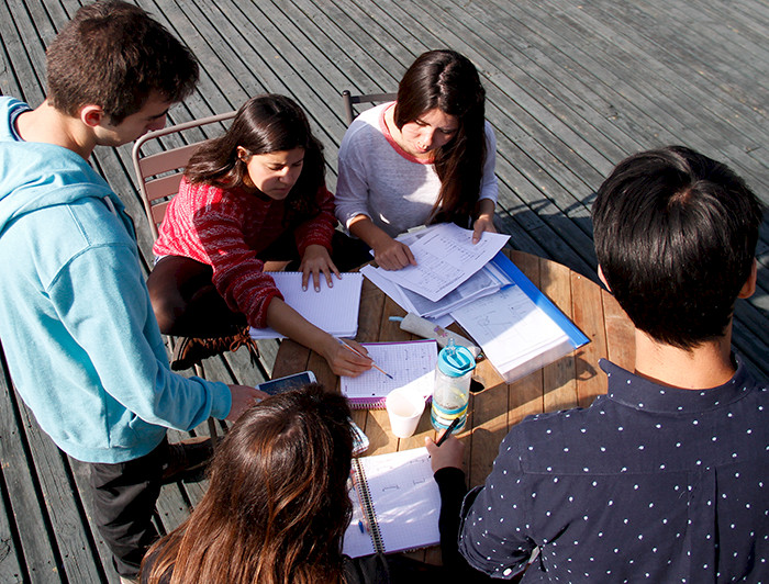 Imagen de alumnos estudiando alrededor de una mesa.