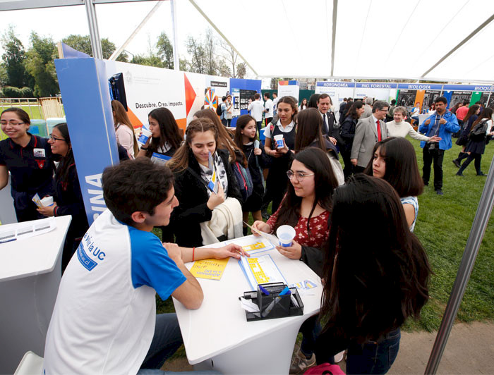 Foto de estudiantes haciendo consultas por carreras en feria.