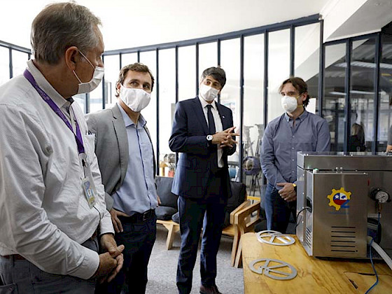 Académicos y estudiantes de ingeniería conversando junto a equipamiento.