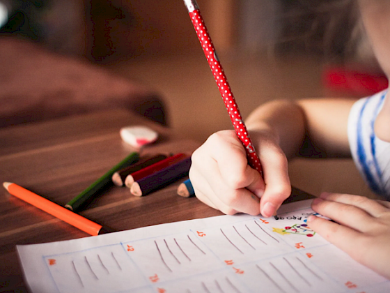 mano de niño escribiendo en un papel