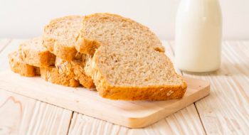 rebanadas de pan de molde en un plato y un vaso con leche blanca