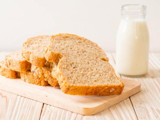 rebanadas de pan de molde en un plato y un vaso con leche blanca