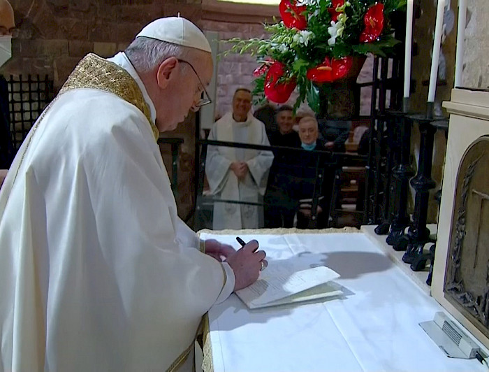 Papa vestido de blanco firmando un papel
