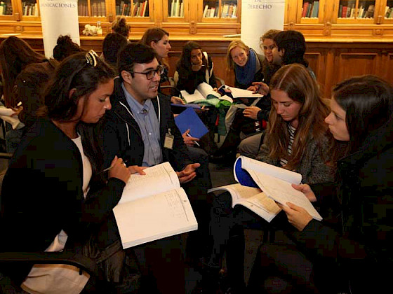 Imagen de un grupo de extranjeros y un orientador de la UC en el salón Manuel José Yrarrázaval, Casa Central.