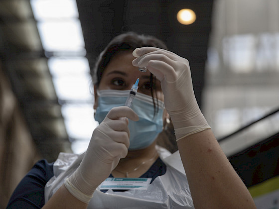 Foto de una mujer con una jeringa y una vacuna