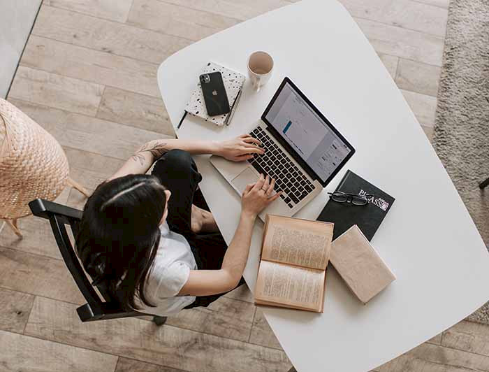 Imagen cenital de mujer escribiendo en su computador.