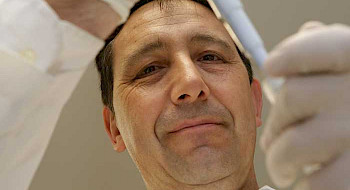 Alexis Kalergis, inmunólogo, manipulando una pipeta.