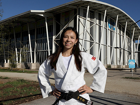 Mary Dee vargas, vestida de judoca, frente al gimnasio de campus San Joaquín.