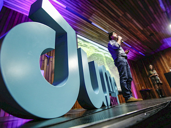 Foto de una persona en un escenario frente a unas letras grandes que dicen JUMP
