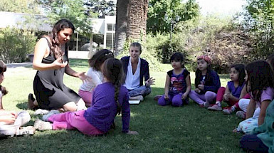 Niños y adultos reunidos y compartiendo en el parque.