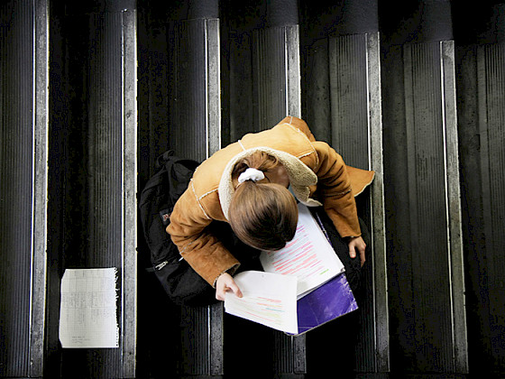 Alumna estudia sobre unas escaleras.