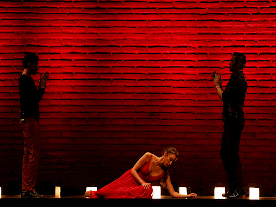 Imagen obra de teatro con fondo rojo.