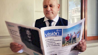 funcionario Luis Iturra leyendo el diario Visión UC en Casa Central.