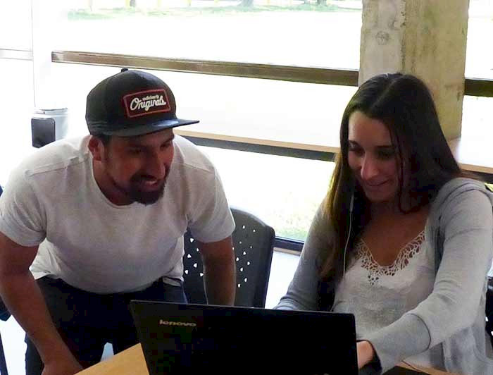hombre y mujer jóvenes mirando pantalla de computador portatil