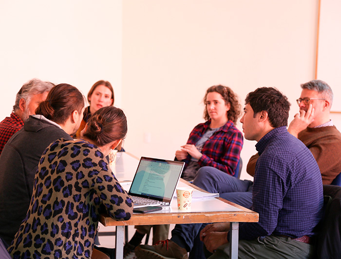 A group of three women and four men are talking in one of the workshops.