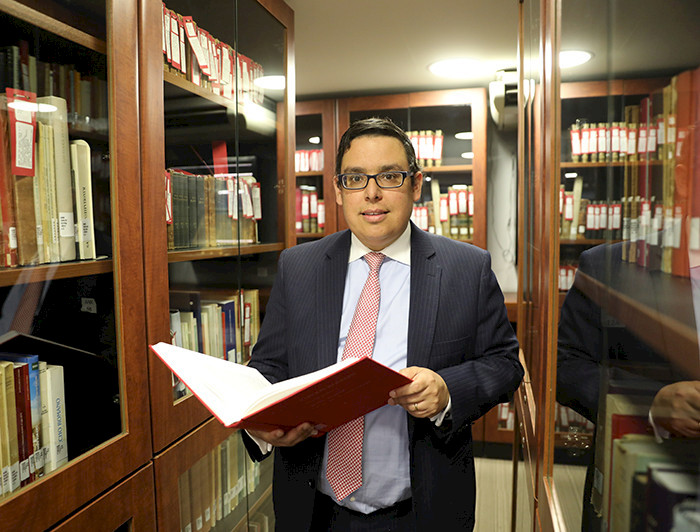 Professor Adolfo Wegmann amidst shelves full of books