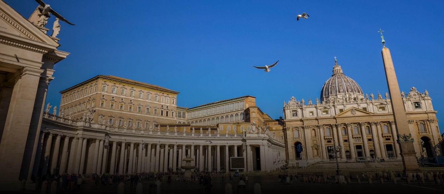 Plaza frente al Vaticano con palomas volando en el cielo.