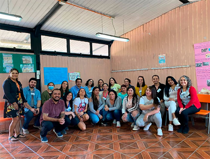 Grupo de mujeres privadas de libertad que participan en el programa ELEDUC, junto a voluntarios en una sala.