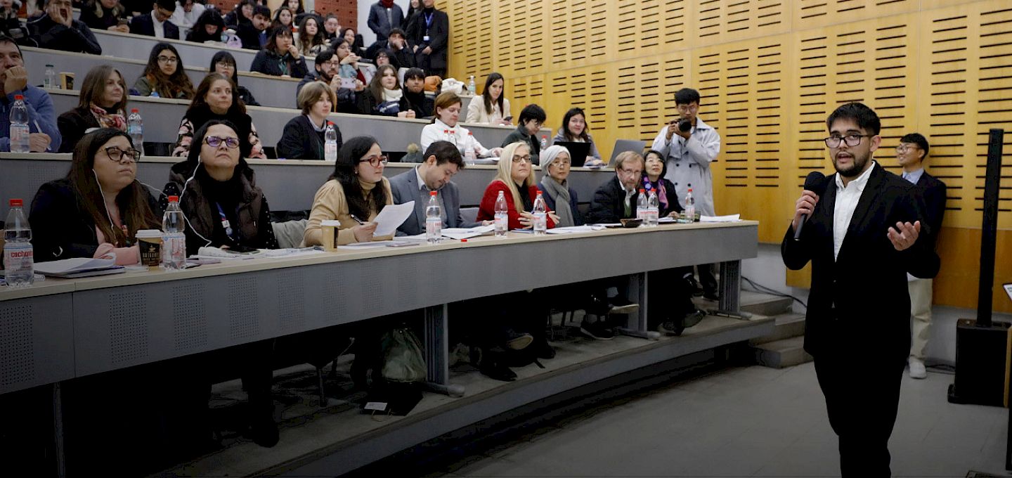 Student presenting a project to an audience and a panel of judges during the Youth Challenge to Alleviate Poverty competition at UC Chile.