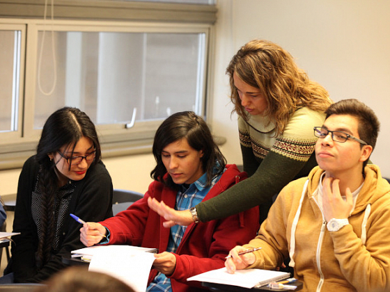 Estudiantes conversando en una sala de clases.
