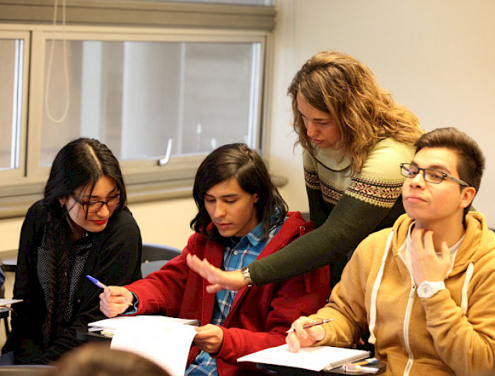 Estudiantes conversando en una sala de clases.