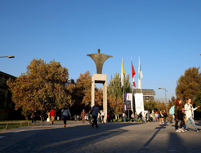 Entrada del campus San Joaquín, con muchas personas entrando y saliendo del lugar.