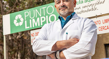 Primer plano del investigador César Sáez, frente a un punto limpio de la Universidad.